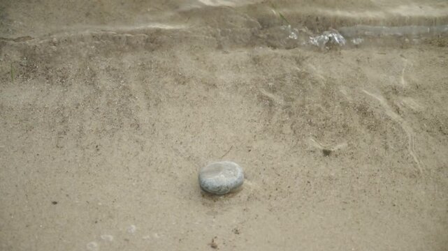 Small sea waves splashing over beach stones