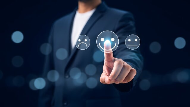 Businessman selecting a happy face icon on a digital screen, customer satisfaction survey concept