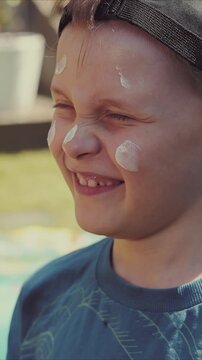 mother applying sunscreen on kids face on sunny summer day. skin protection from sunburn