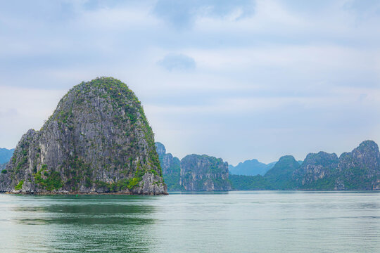 Beautiful Halong bay with layer of limestone mountians and boats in Vietnam.
