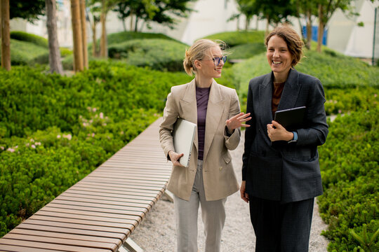 Colleagues walk together in a garden while discussing work and sharing ideas