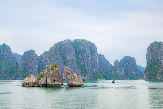 Beautiful Halong bay with layer of limestone mountians and boats in Vietnam.