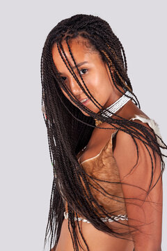 Young black woman with braided hair wearing traditional African animal hide top and beaded necklace