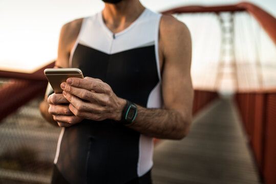 runner exhausted from effort checks his stats on mobile phone