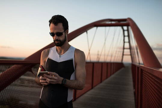 runner exhausted from effort checks his stats on mobile phone