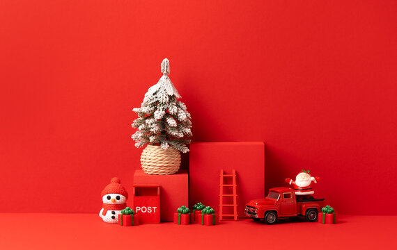 Christmas Scene with Snowy Pine Tree, Red Podium, Toy Truck, Snowman, Santa and Gifts on Red Background