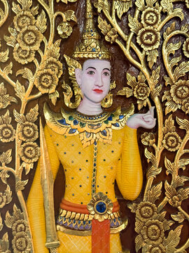 Ornate gilded wood carving of a guardian deity in yellow attire at a Chiang Mai temple