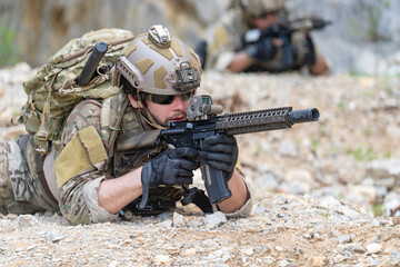 Fototapeta premium Soldier in tactical gear aiming rifle during military training exercise