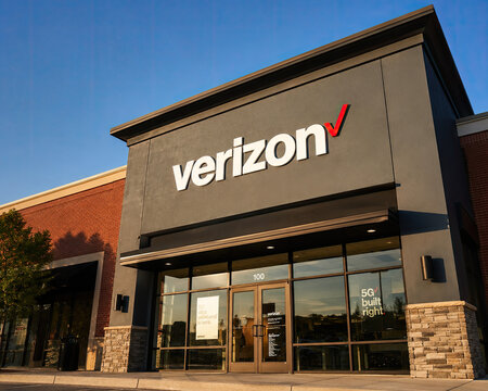 Verizon store storefront with large white and 5 G advertisement on glass doors building exterior