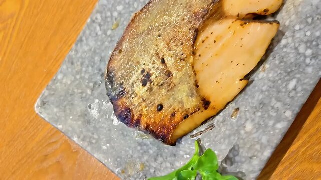 Saikyo Miso Grilled Yellowtail amberjack fish fillet served with lemon slice on plate, Japanese Seafood Cuisine, Marinated Meat, Omega Protein Delicacy, Panning Shot