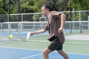 Obraz premium Active Diverse People Playing Pickleball on Outdoor Court