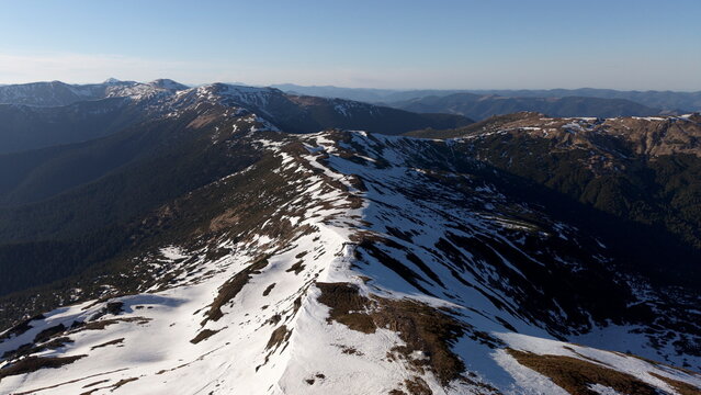 Aerial perspective of winding snow covered mountain ridge in Ukrainian Carpathians