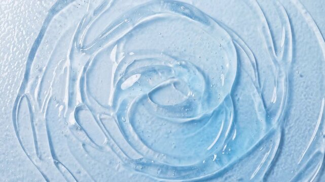 Close-up of light blue gel texture with bubbles. Swirling motion of cosmetic serum. Copper peptides and hydration concept. Top view of viscous liquid ripples