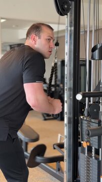 Man performing triceps pushdown with rope attachment