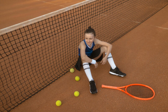 M&auml;dchen, 11, im Tennisoutfit am Tennisplatz