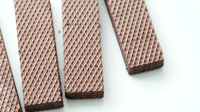Placing chocolate filled waffles one by one on a white porcelain saucer
