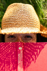 Obraz na płótnie Canvas Woman reading outdoors under sunlight.
