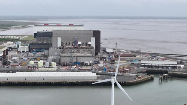 Panning drone aerial wind turbine with Heysham nuclear power stations aerial