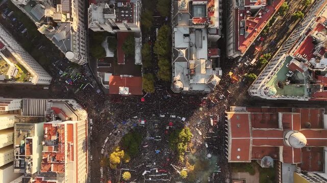 Students gathering at Plaza de Mayo to protest against Javier Milei's government leadership, aerial shot top down view, descending