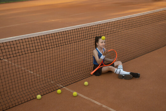 M&auml;dchen, 11, im Tennisoutfit am Tennisplatz