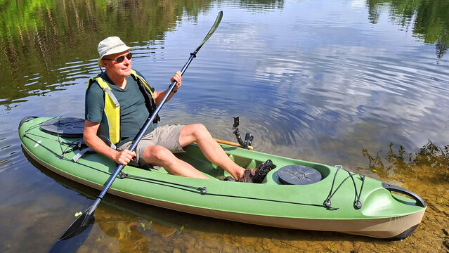 Man kayaking enjoying summer vacation on mountain lake.
