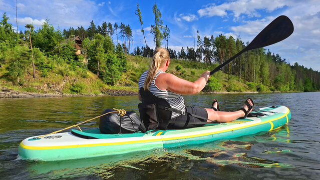 Woman kayaking enjoying summer vacation on mountain lake.