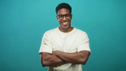 Fototapeta premium Man wearing glasses with arms crossed in studio and later adjusting glasses; confidence approachability.