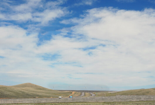 Traffic on Interstate 80 in southern Wyoming with wind turbines in the distance