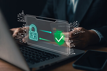 Fototapeta premium Businessman holding credit card using laptop with virtual secure payment shield interface. Cyber security, financial data protection concept.