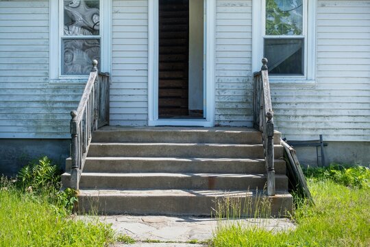 Weathered concrete entry steps of an old house needing renovation