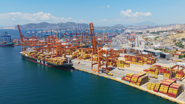 Large msc container ship docking at piraeus port amid stacked containers and gantry cranes, busy cargo terminal illustrating international shipping, logistics and trade operations