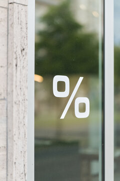 Prozentzeichen an der schmutzigen Schaufensterscheibe eines Gesch&auml;fts als Hinweis auf einen Sale