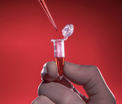 Hand holding test tube as pipette tip drips sample