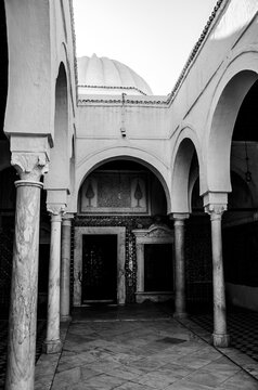 Black and white view of marble columns and arches in a historic Islamic courtyard
