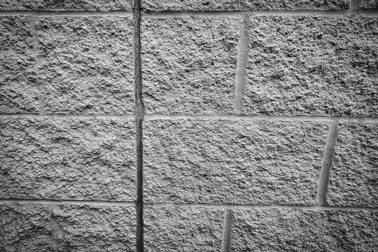 grey textured concrete block wall with a rough split-face surface and detailed grout lines. architectural, industrial, construction, and abstract background 