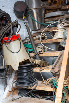 Cluttered workshop storage with tools cables and equipment.