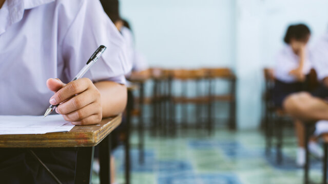 Close-up of Student Hand Writing on Exam Paper with Pen