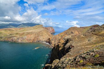 Obraz premium Colorful layered cliffs jutting into turquoise sea