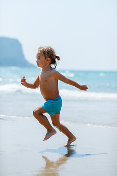 Toddler Running On Sandy Beach