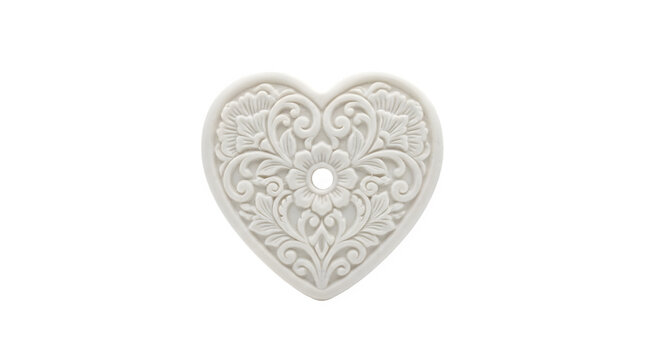 A beautiful white heartshaped ceramic or plaster ornament with intricate floral and scrollwork carvings isolated on transparent background