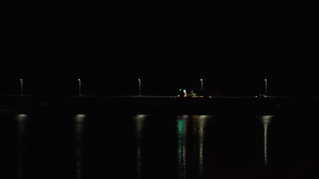 夜の佐賀県唐津市で水面に美しく反射する街灯の光と橋の4K動画
