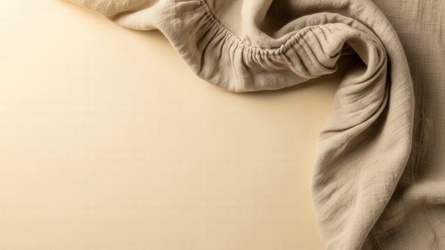 Light beige background with soft fabric draping across, rustic and textured textile design element.