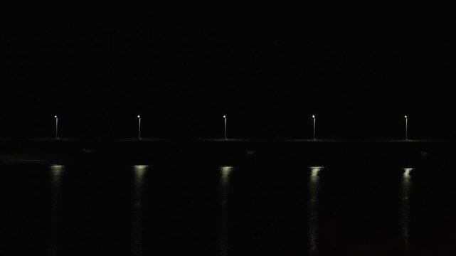 夜の佐賀県唐津市で水面に美しく反射する街灯の光と橋の4K動画