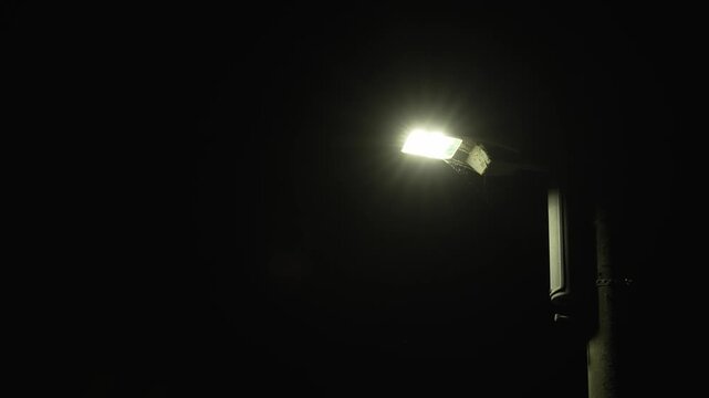 夜の暗闇の中で白く明るく輝く街灯の照明の4K動画
