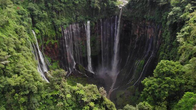 Drone Forward Flight Above Rainforest Revealing Tumpak Sewu Waterfall in Valley Below, Java, Indonesia
