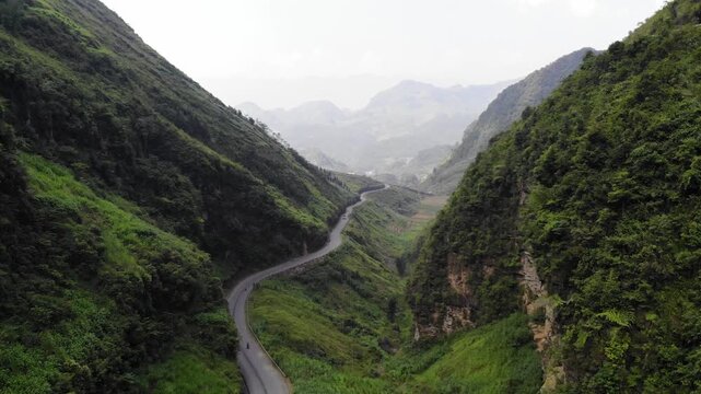 Aerial Drone Flying Over Winding Ha Giang Loop Road Panning Down Between Mountain Ranges, Northern Vietnam