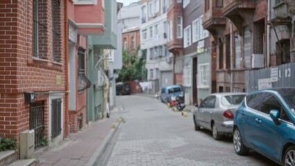 Fototapeta premium Narrow urban street with parked cars and brick facades, defocused shallow bokeh street; background backdrop copyspace calm.