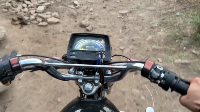 Motorcycle ride view showing dashboard and handlebars on a narrow rural path.