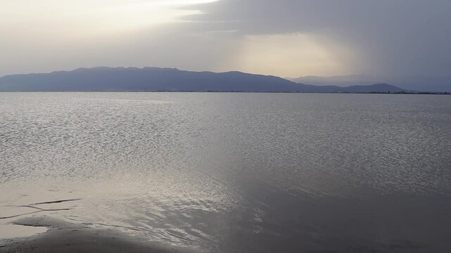 Calm sea water reflecting the sunlight at sunset in the ebro delta