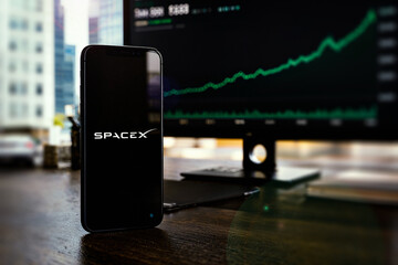Obraz premium SpaceX Logo Displayed On Smartphone Screen, Space Exploration Technologies Corp IPO (Initial Public Offering), Green Stock Exchange Market Trading Chart, SPCX IPO, London, UK - June 2026